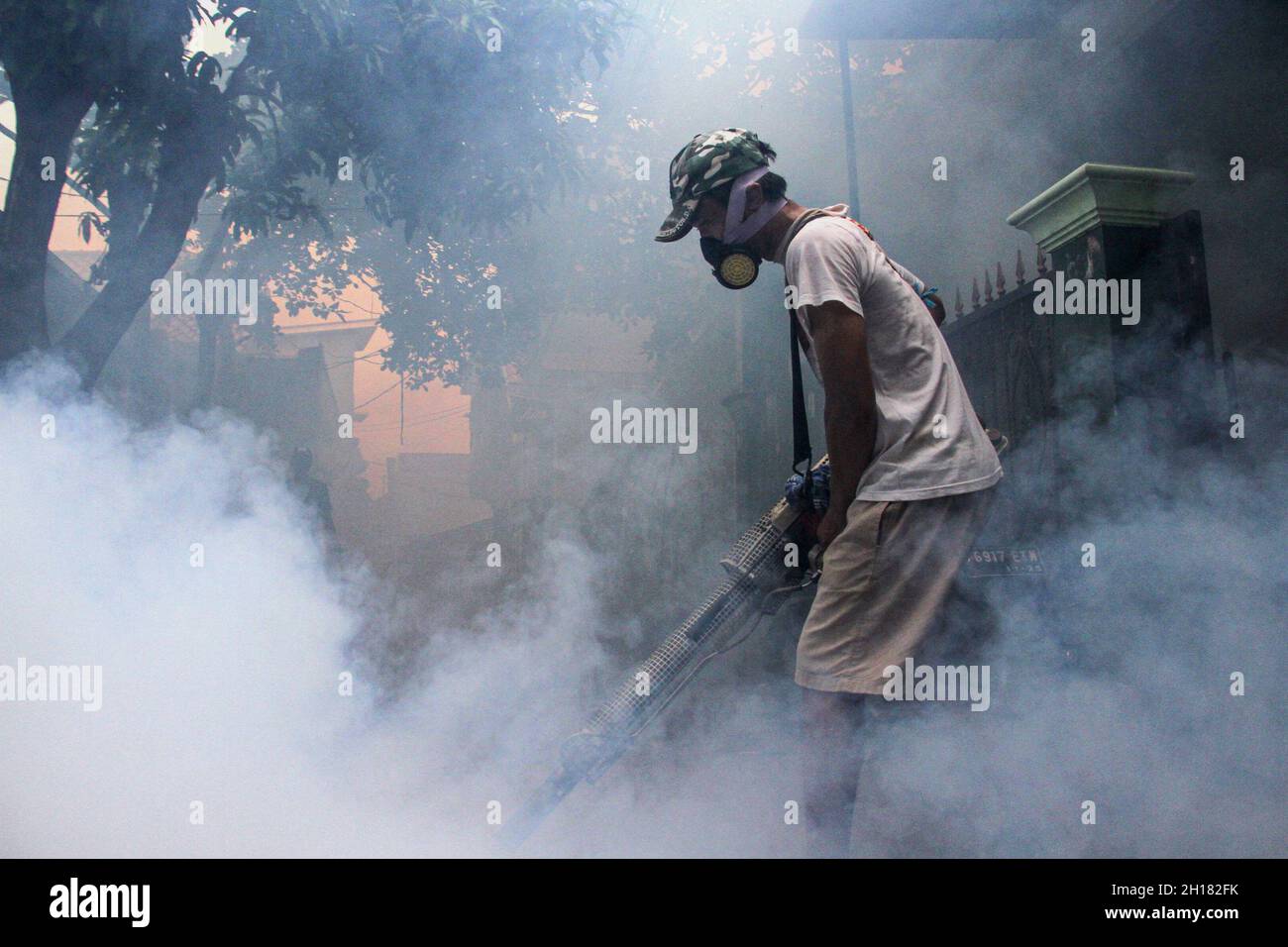 Depok, Indonesia. 17th Oct, 2021. A worker sprays anti-mosquito fog at a residential area in Depok, West Java, Indonesia, Oct. 17, 2021. Credit: Dedi Istanto/Xinhua/Alamy Live News Stock Photo