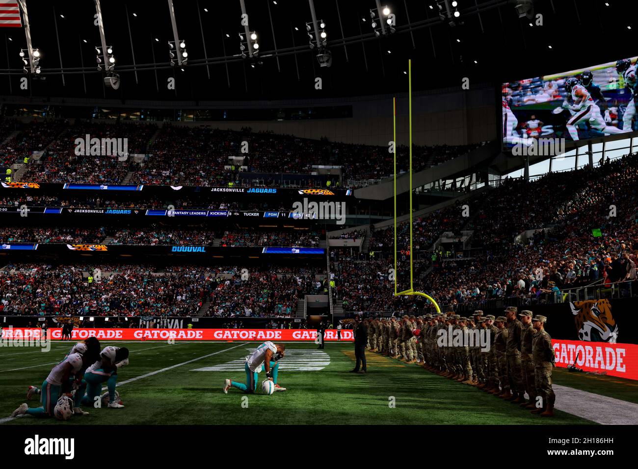 London, UK. 17th October 2021; Tottenham Hotspur stadium, London, England; NFL UK Series, Miami Dolphins versus Jacksonville Jaguars; Miami Dolphins Linebacker Brennan Scarlett (57) kneels in front of the U.S military service members Credit: Action Plus Sports Images/Alamy Live News Stock Photo