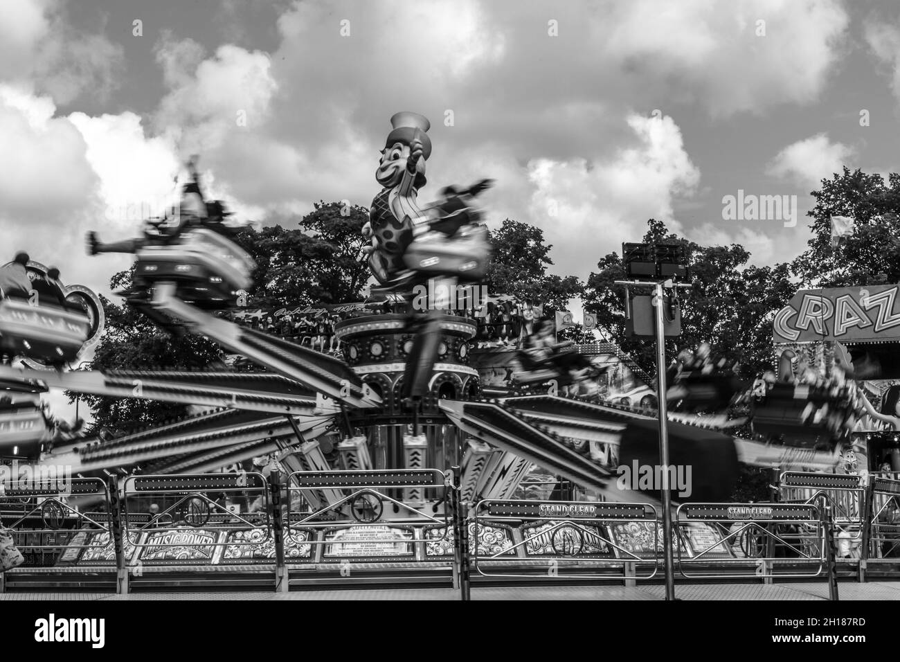 The speed of the Octopus fairground ride seen in monochrome. Taken in 'The Walks', Kings Lynn on 28th Aug 2021. Stock Photo