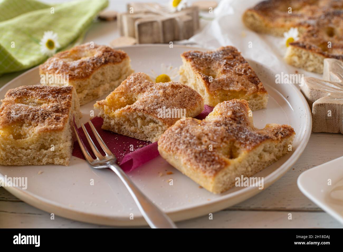 Butter cake with sugar topping. Delicious sheet cake or yeast cake with butter and topped with sugar. served in pieces on a plate with fork Stock Photo