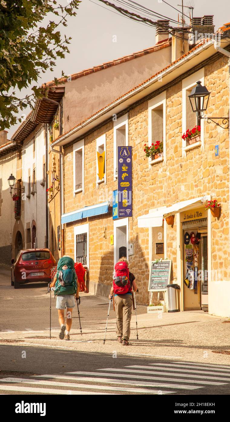 Pilgrims walking through the village of Zariquiegui  standing above Pamplona on the Spanish pilgrim route the Camino de Santiago the way of St James Stock Photo