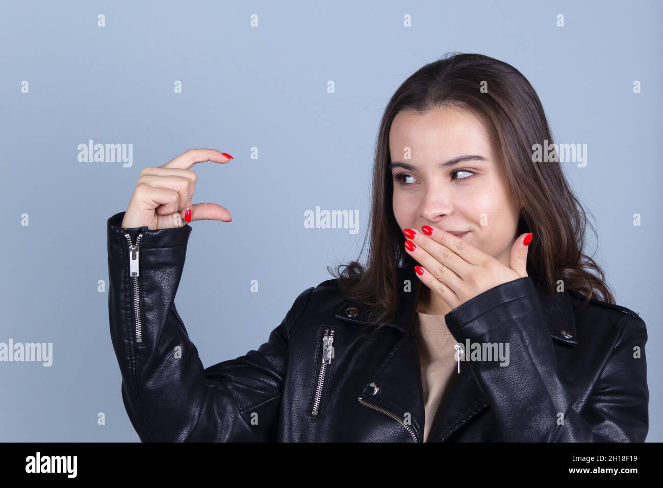 Pretty brunette shows the finger gesture little Stock Photo