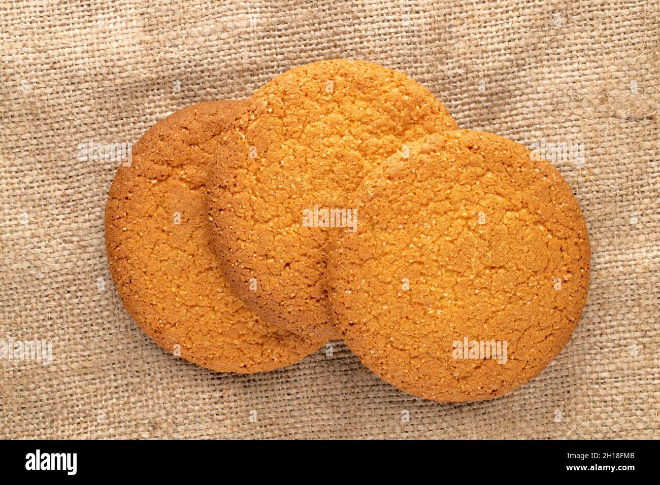 Three sweet round American cookies, close-up, on a jute fabric, top ...