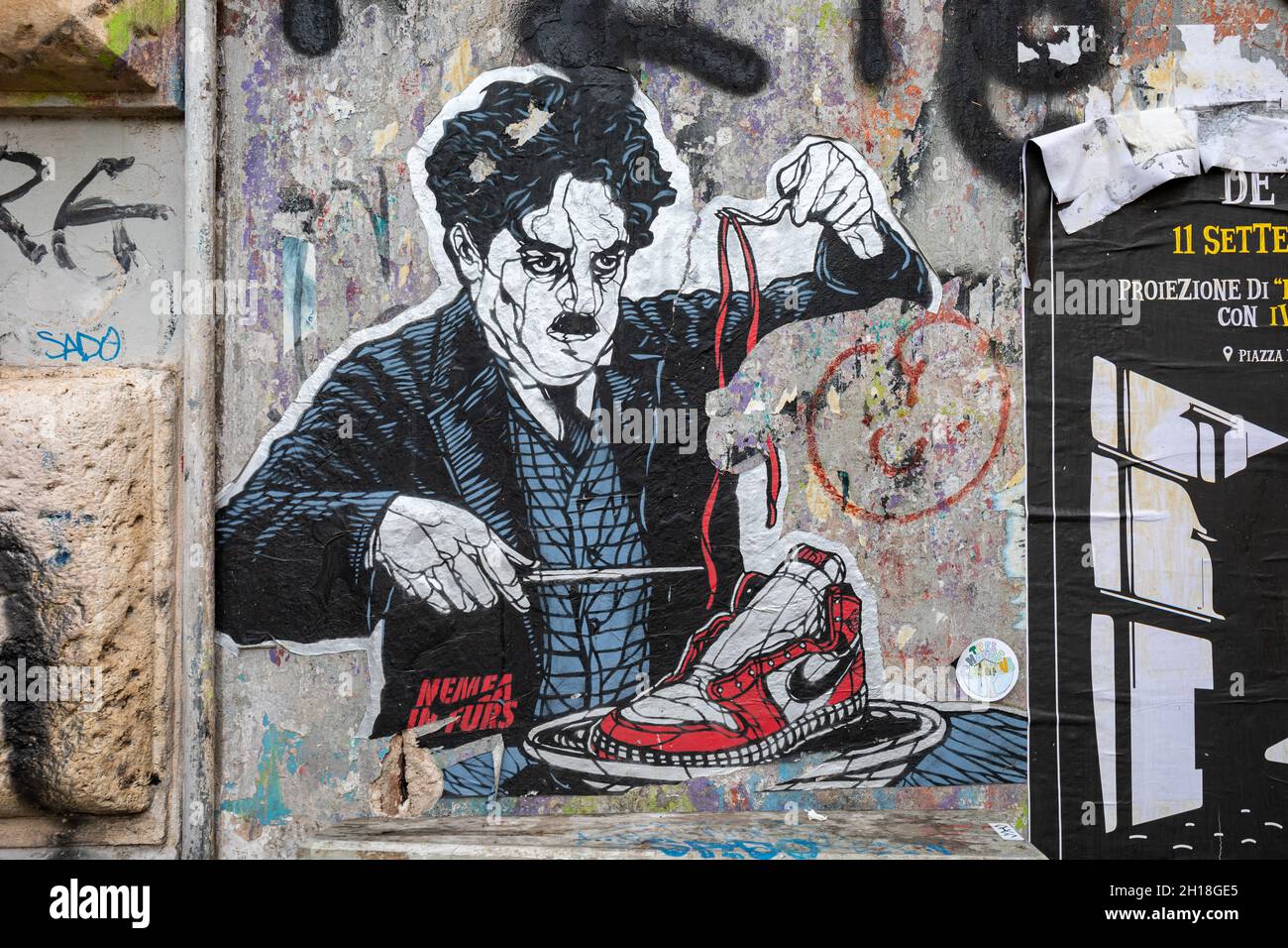 Cut-to-shape street art poster of Charlie Chaplin eating Nike sneaker.  Trastevere district of Rome, Italy Stock Photo - Alamy
