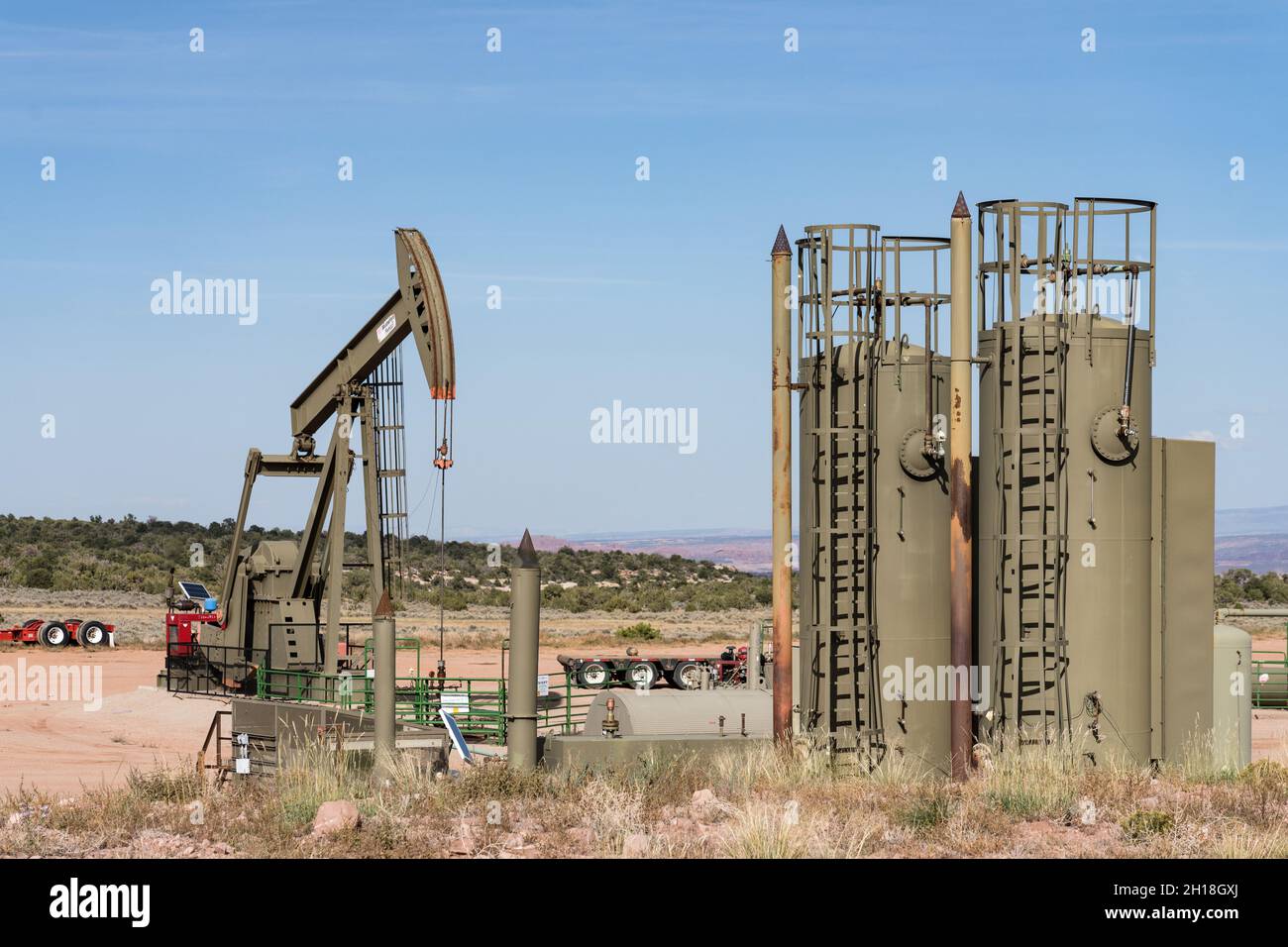 A conventional horsehead oil well pump jack unit and heater treaters on an oil well site in Utah. Stock Photo