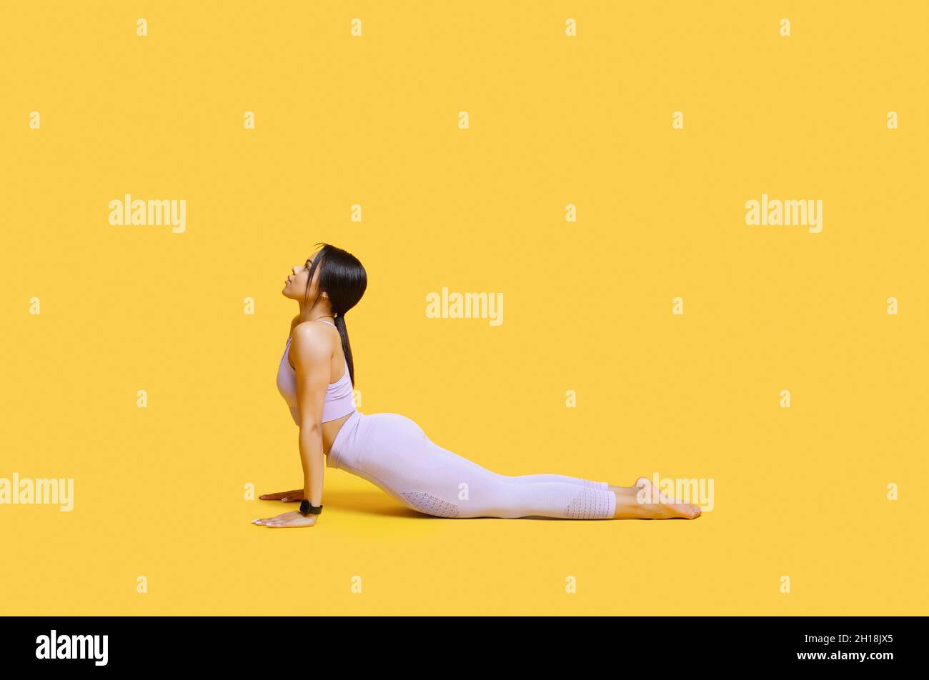 Working out. Young black woman practicing yoga, doing Cobra exercise ...