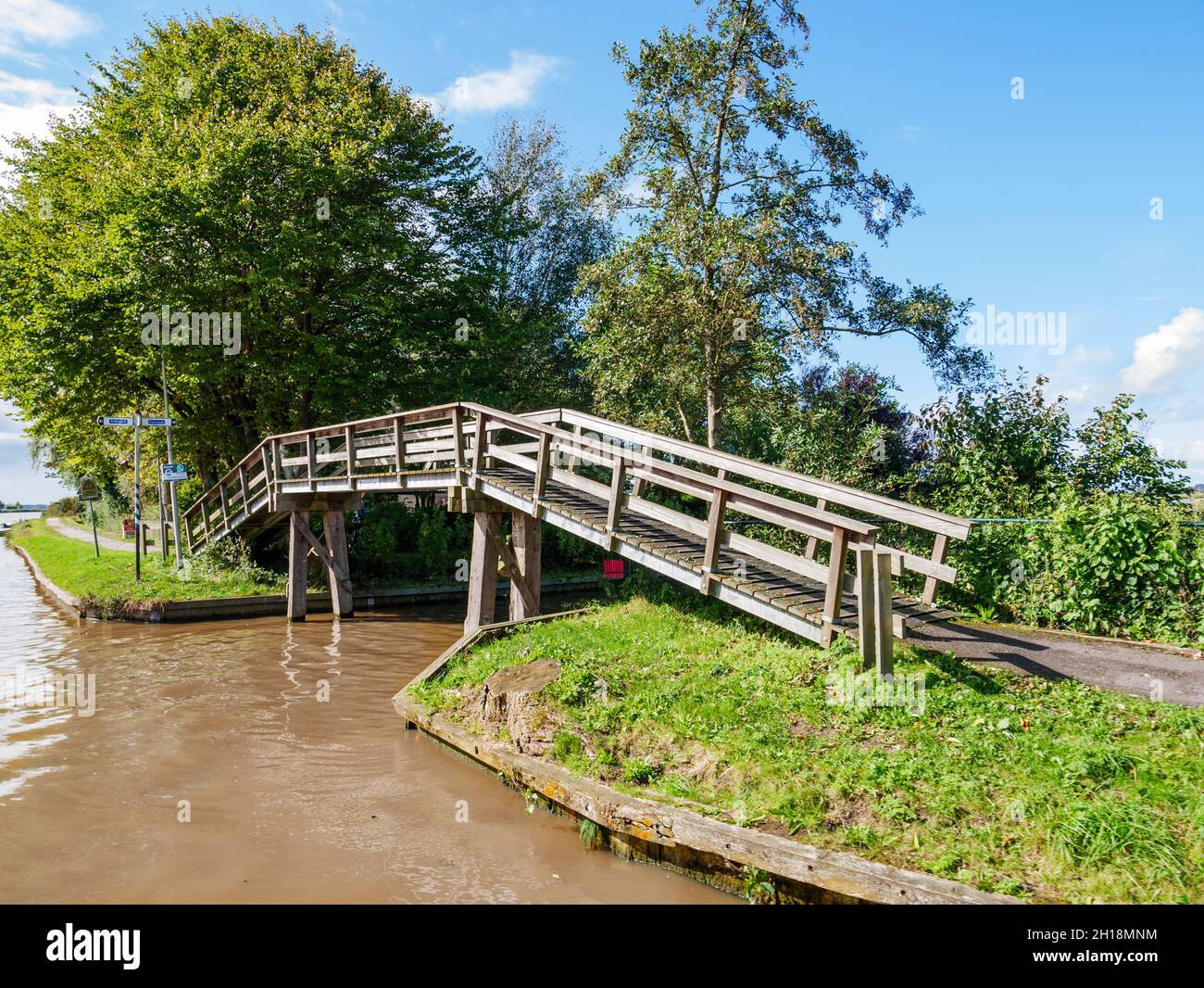 Wooden footbridge for bicycles and pedestrians by Dokkumer Ee in town of Bartlehiem, Friesland, Netherlands Stock Photo