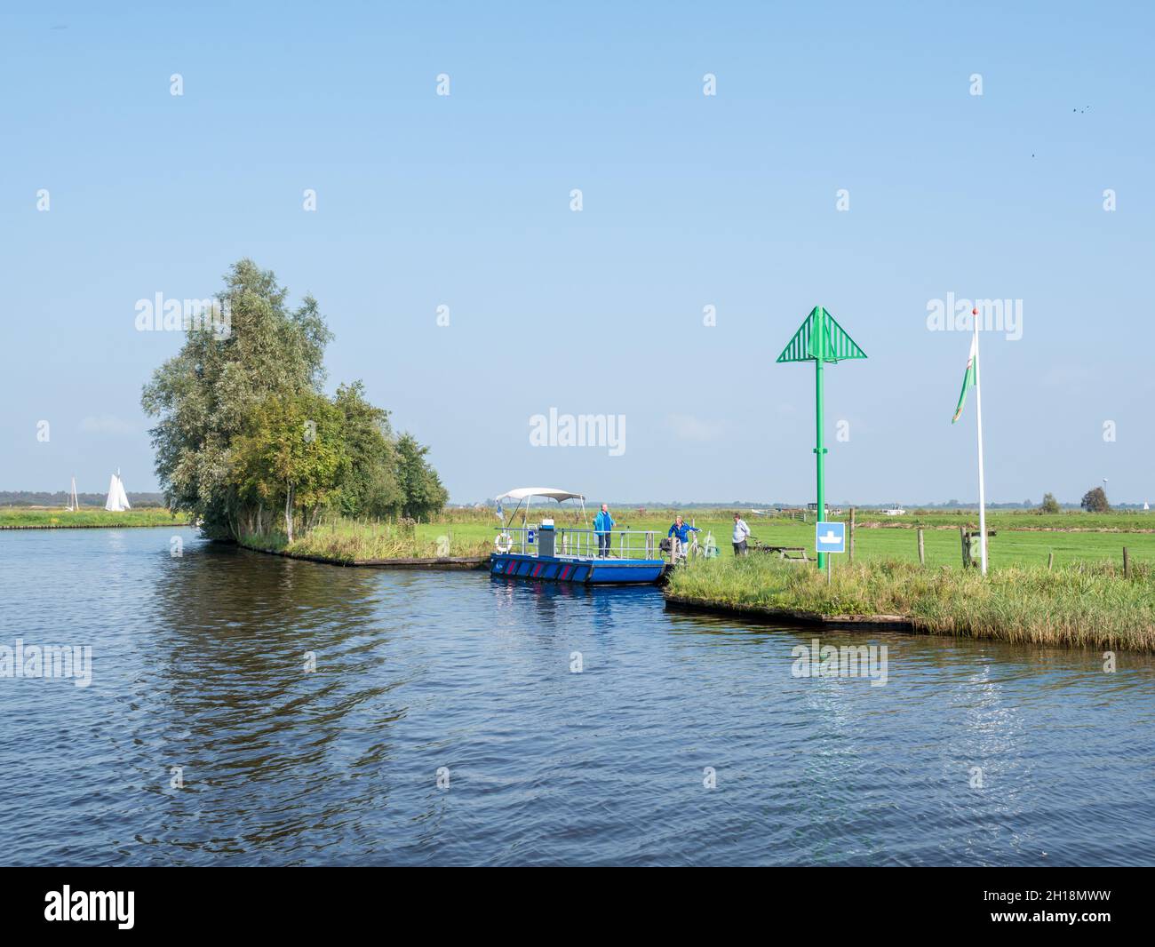 Senior couple with bicycles leaving foot ferry Snoeckbears after crossing canal near Grou, Friesland, Netherlands Stock Photo