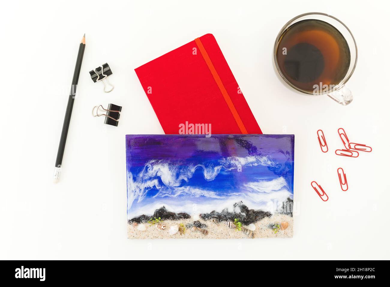 Resin art with red diary, clips, pencil and cap of tee on white background. Flat lay, Top view Stock Photo
