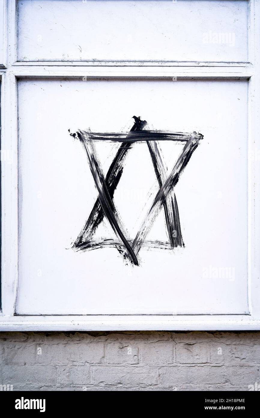 Star of David hexagram graffiti in black paint on white panel Stock Photo
