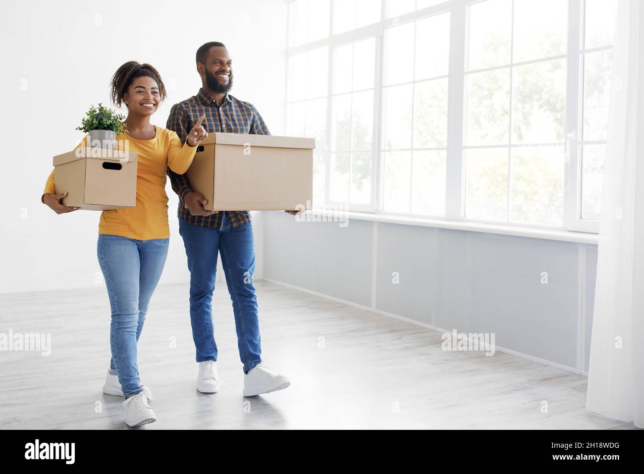 Cheerful millennial african american couple enjoying moving in new ...