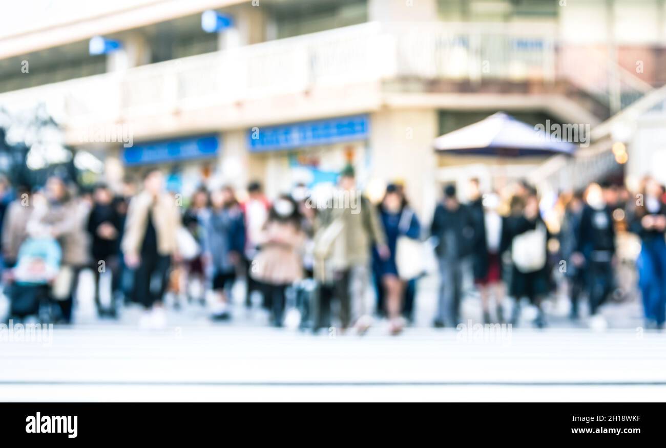 Blurred defocused abstract background of people walking on street - Crowded city center at rush hour in urban area over zebra crossing Stock Photo
