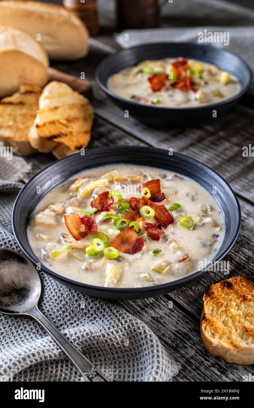 Hearty New England style clam chowder with smoky bacon and scallions. Stock Photo