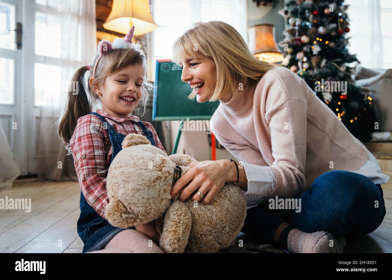 Portrait of happy mother and her child girl playing and having fun together at home Stock Photo