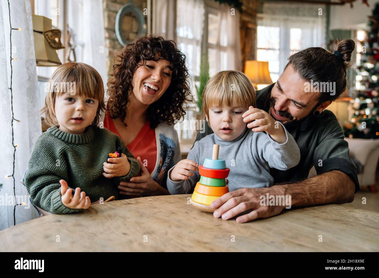 Family and childhood concept. Young parents spending time together with children at home. Stock Photo