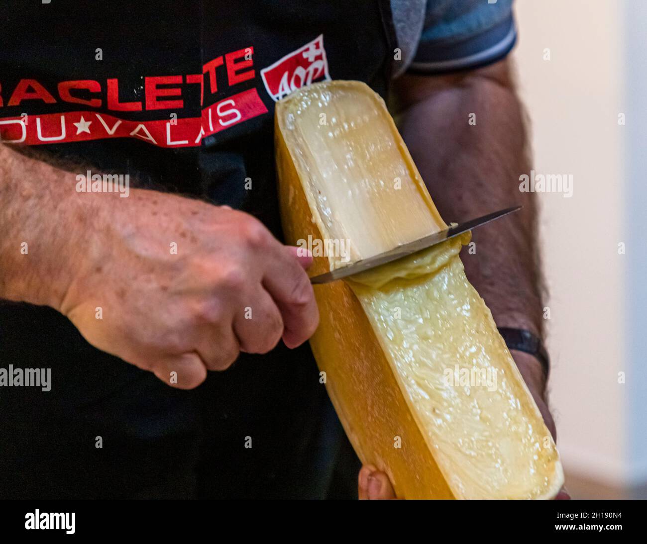 In one go: This is how the professionals do it today and it is also the learning objective during the raclette internship at the Augstbord cheese dairy in Turtmann-Unterems, Switzerland Stock Photo