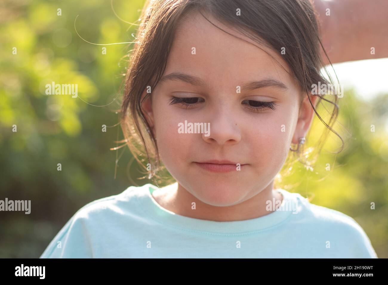 Lovely portrait of a little girl with closed eyes. Photo at golden hour
