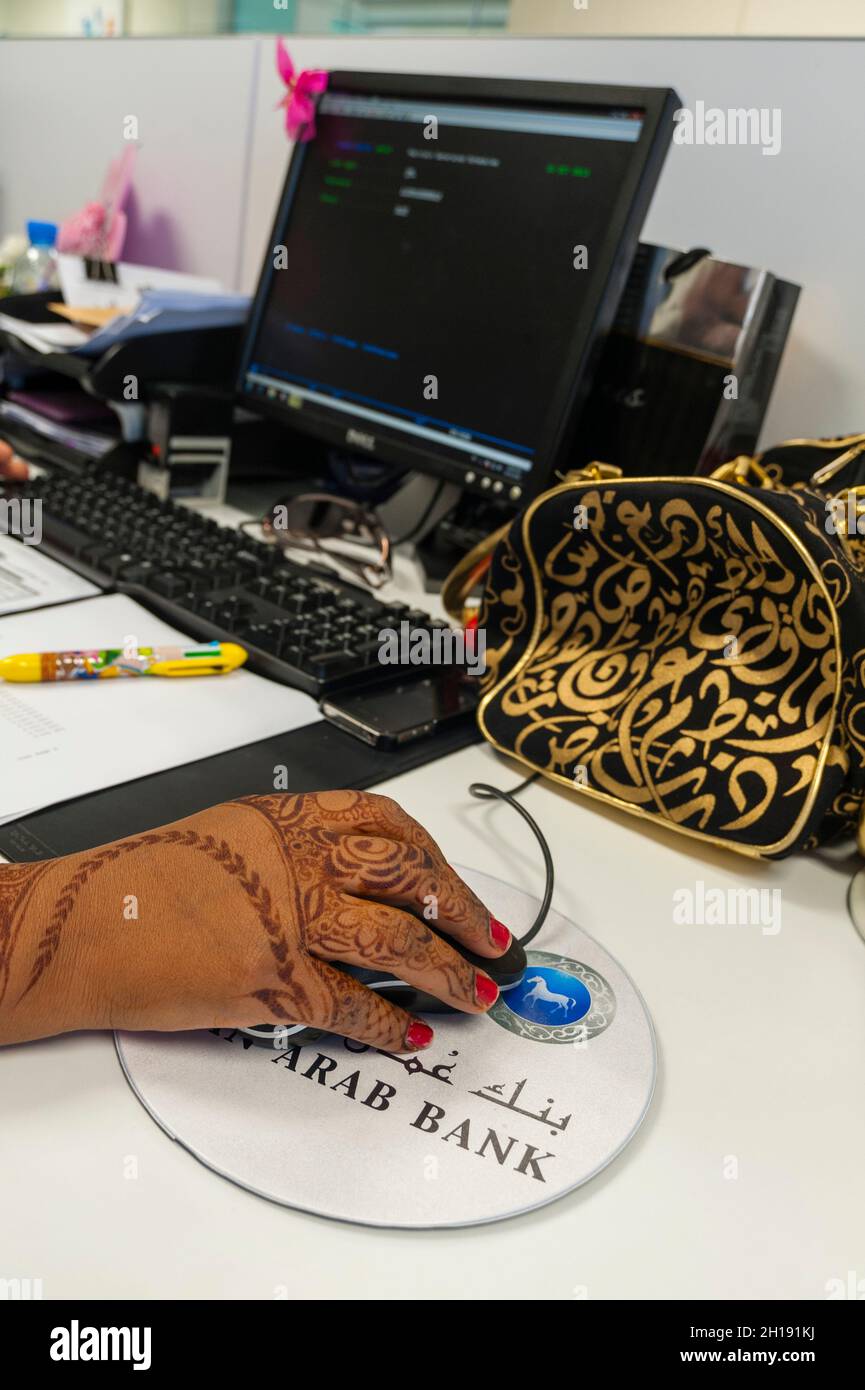 A woman's hand painted with henna works a mouse at the call center of the Oman Arab bank. Muscat, Oman. Stock Photo
