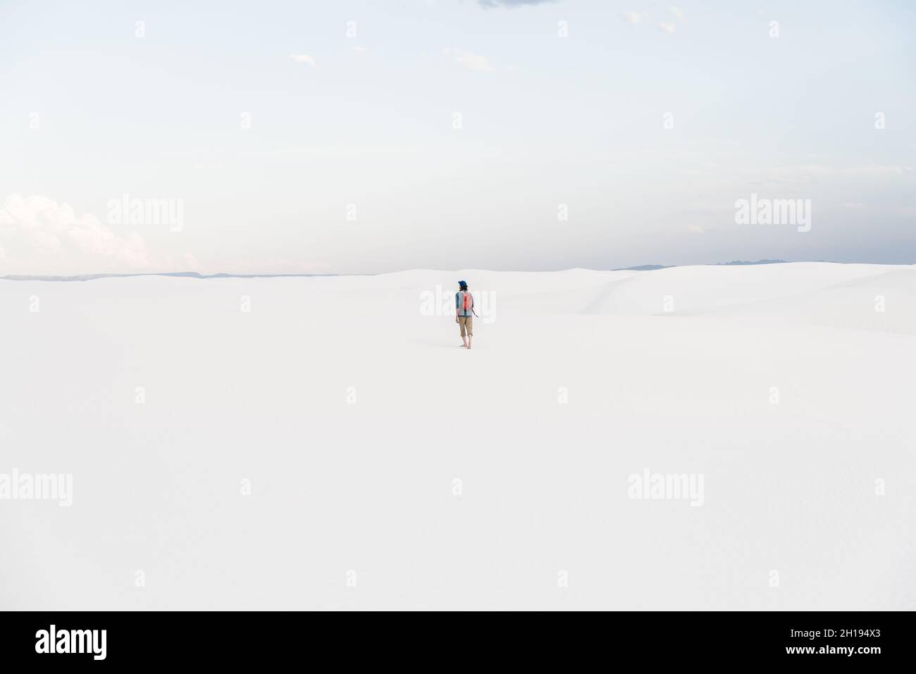 A man walking across the sand dunes at White Sands National Park in