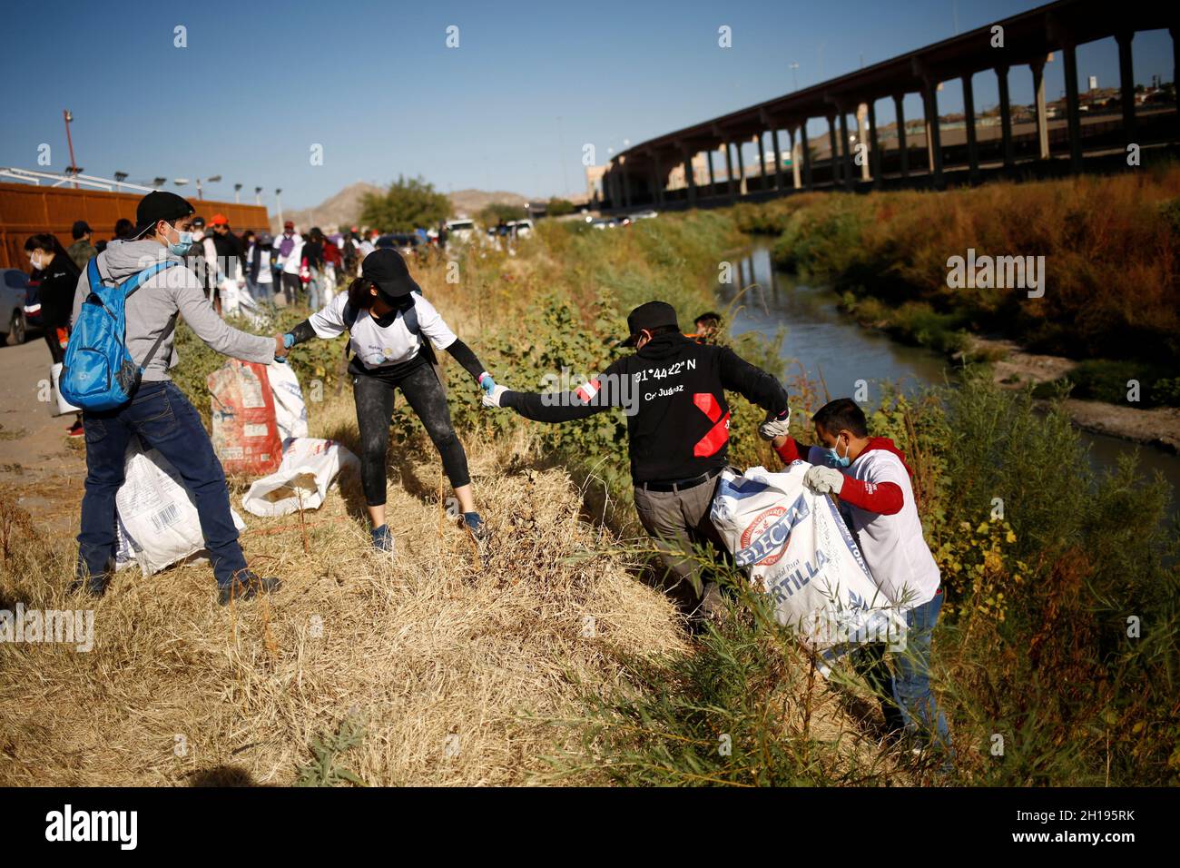 Volunteers and Rotary club members clean up the Rio Bravo river, on the border line between Mexico and U.S., with the aim of protecting the environment, as seen from Ciudad Juarez, Mexico October 17, 2021. REUTERS/Jose Luis Gonzalez Stock Photo