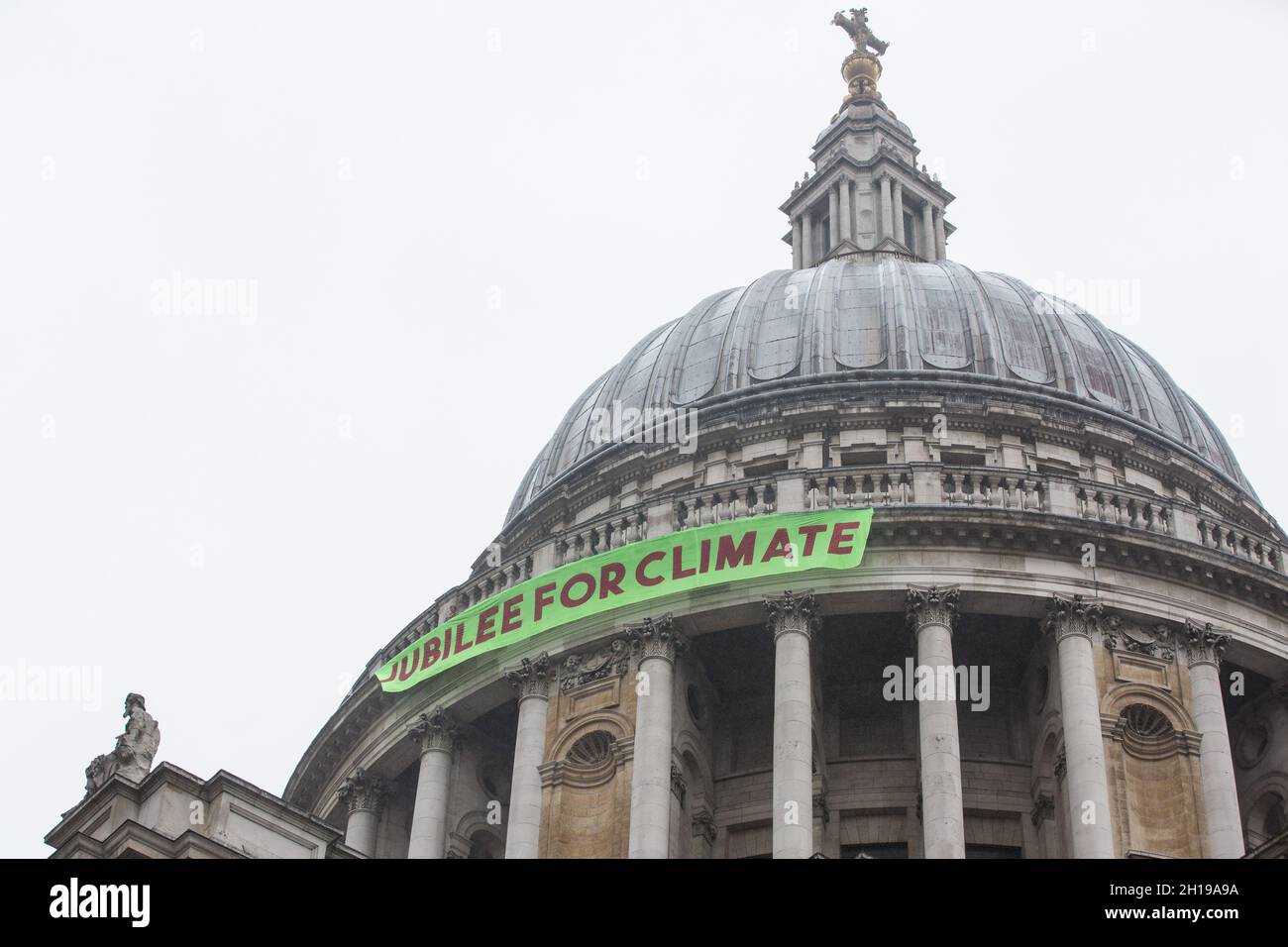 London, UK. 15th October, 2021. Activists from Africans Rising UK drop a banner from St Paul's Cathedral on the anniversary of the assassination of the Pan-Africanist President of Burkina Faso Thomas Sankara to launch the Jubilee for Climate Campaign. The Jubilee for Climate Campaign is an umbrella campaign both for the cancellation of debts for which Sankara fought so hard as well as for progressive and unifying policies to tackle the climate crisis which amplify voices from the Global South. Credit: Mark Kerrison/Alamy Live News Stock Photo