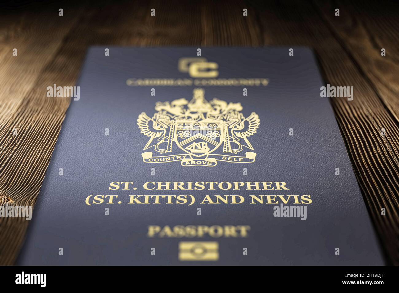 Close-up of saint kitts and nevis passport on a dark wooden board, citizenship by Investment Stock Photo