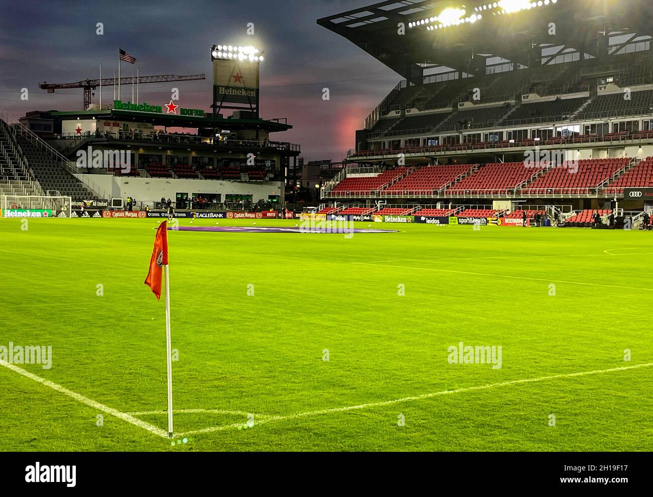Red glow in the sky at a soccer stadium after a storm Stock Photo