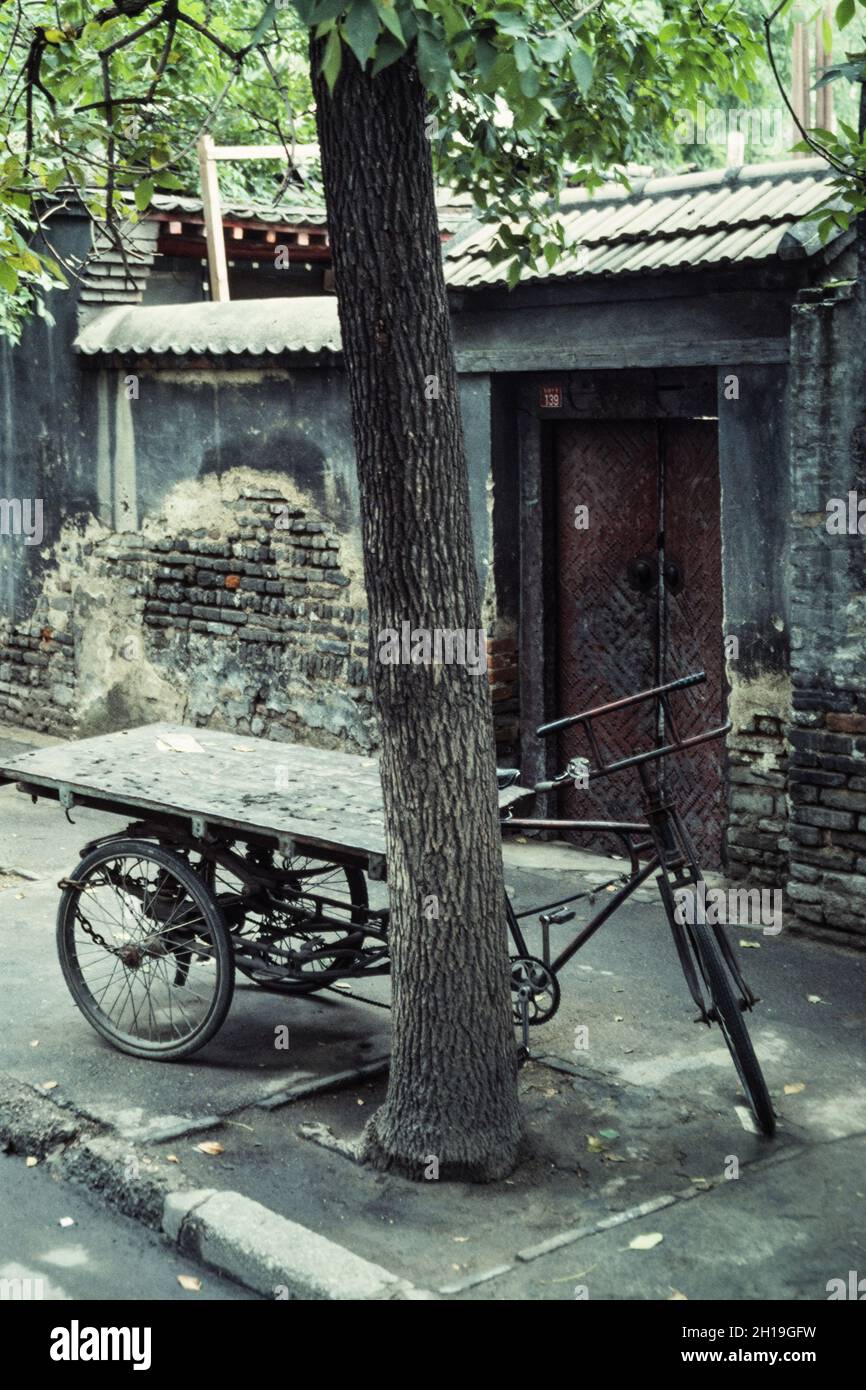 A cargo tricycle parked on the sidewalk in front of an old traditional ...