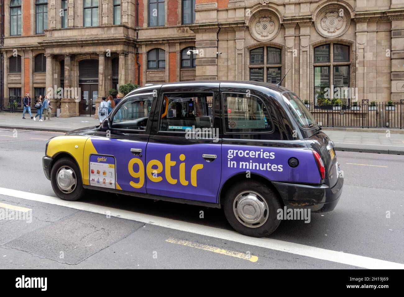 Black taxi cab advertising rapid delivery service Getir, London England United Kingdom UK Stock Photo