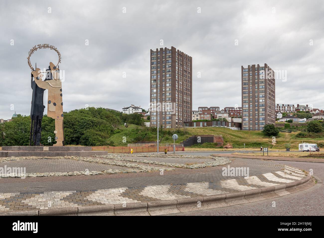 New Brighton, UK: King's Parade Clown roundabout sculpture and The Cliff high rise flats on the North Wirral coast. Stock Photo