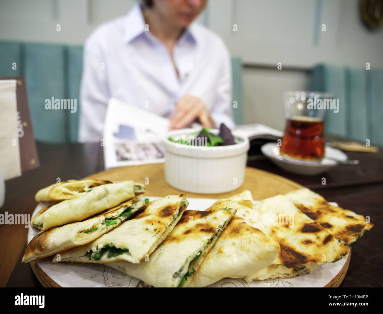 Close-up of tandir bread in Baku restaurant with silhouette of woman reading menu before Stock Photo