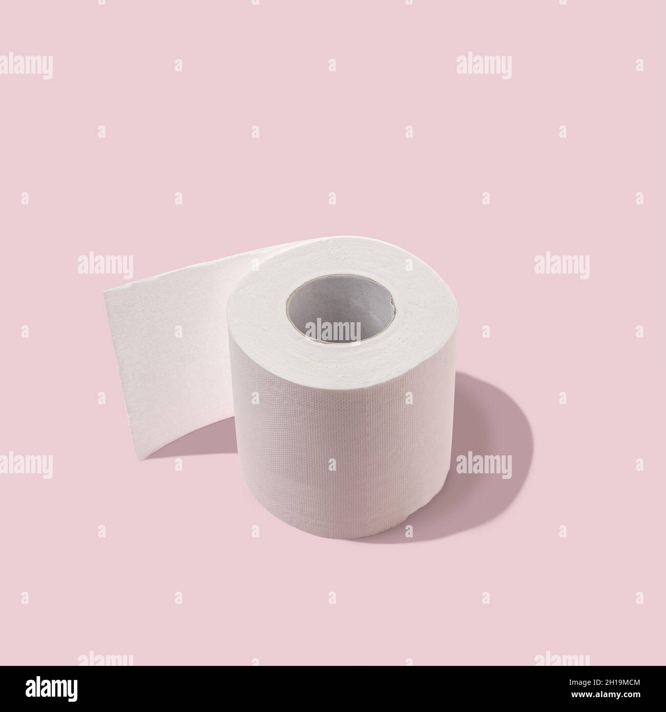 Toilet paper roll on pastel pink backdrop. Minimal Coronavirus outbreak