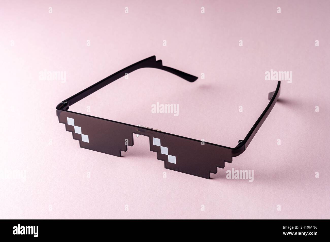 Meme Pixel glasses on pink background. Minimal concept. Stock Photo