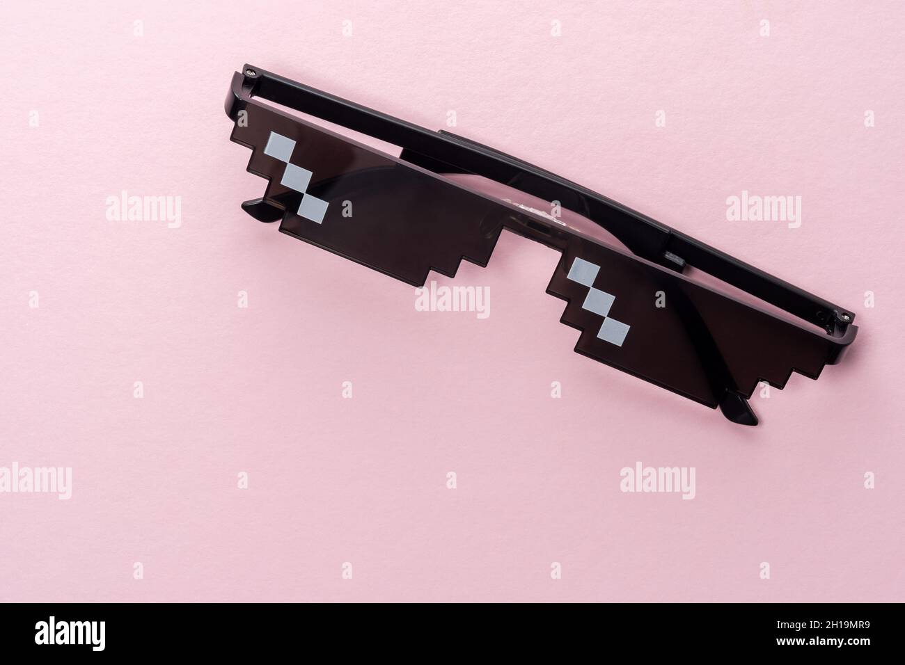 Meme Pixel glasses on pink background. Minimal concept. Stock Photo