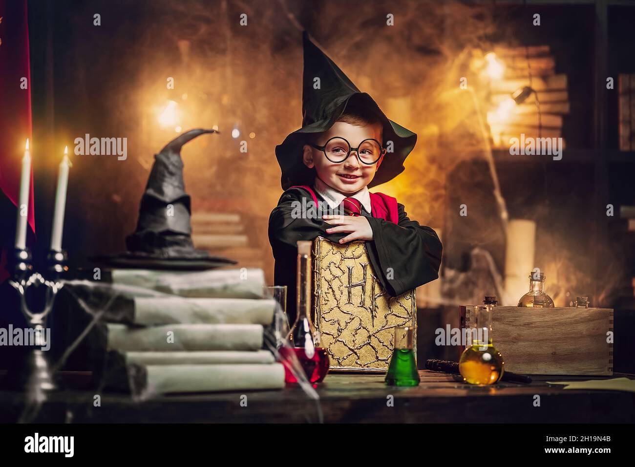 Small wizard in glasses, wizard's hat holds magic book. Cosplay