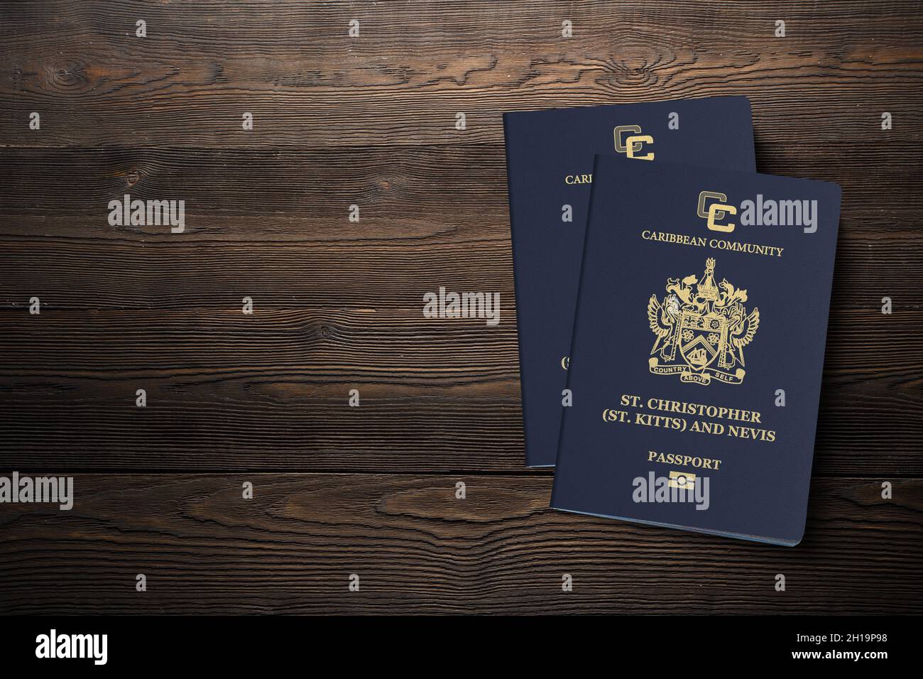 Two Saint Kitts and Nevis passports on a wooden background, citizenship by investment Stock Photo