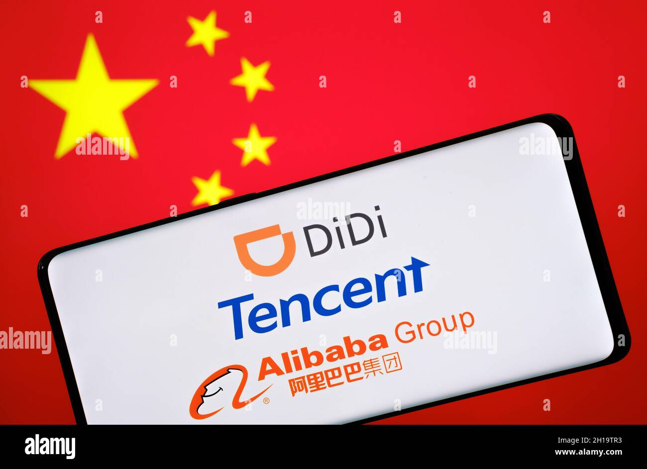 Chinese BigTech concept. DiDi, Tencent, Alibaba logos seen on smartphone and blurred flag of China on the background. Stafford, United Kingdom, Octobe Stock Photo