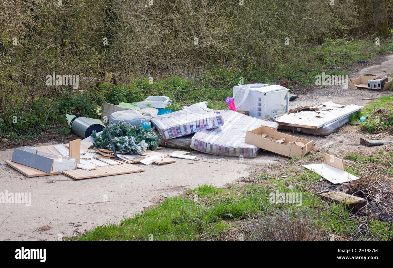 Illegal fly tipping or fly dumping. Garbage or waste dumped on a country lane, UK Stock Photo