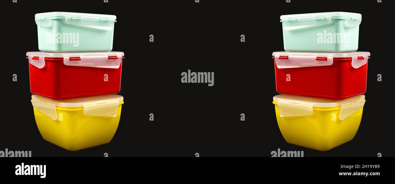 Multicolored plastic lunch boxes on a black background from both sides, banner Stock Photo
