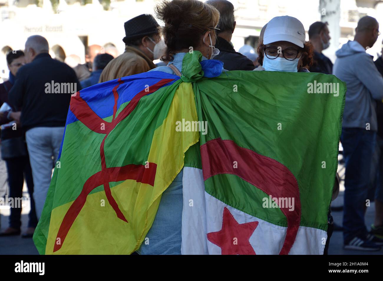 Marseille, France. 17th Oct, 2021. A woman holds a Kabyle flag (L) and an Algerian flag (R) during the anniversary.People gathered for the 60th anniversary of October 17, 1961. On that day, dozens of Algerians were killed during a demonstration in Paris fiercely suppressed by the police. Credit: SOPA Images Limited/Alamy Live News Stock Photo