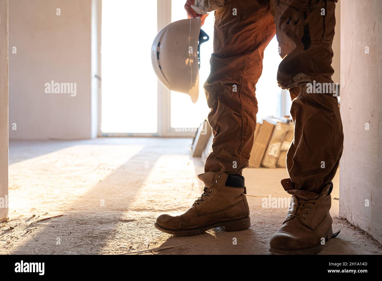 A man builder with a helmet in his hands, copy space. Stock Photo