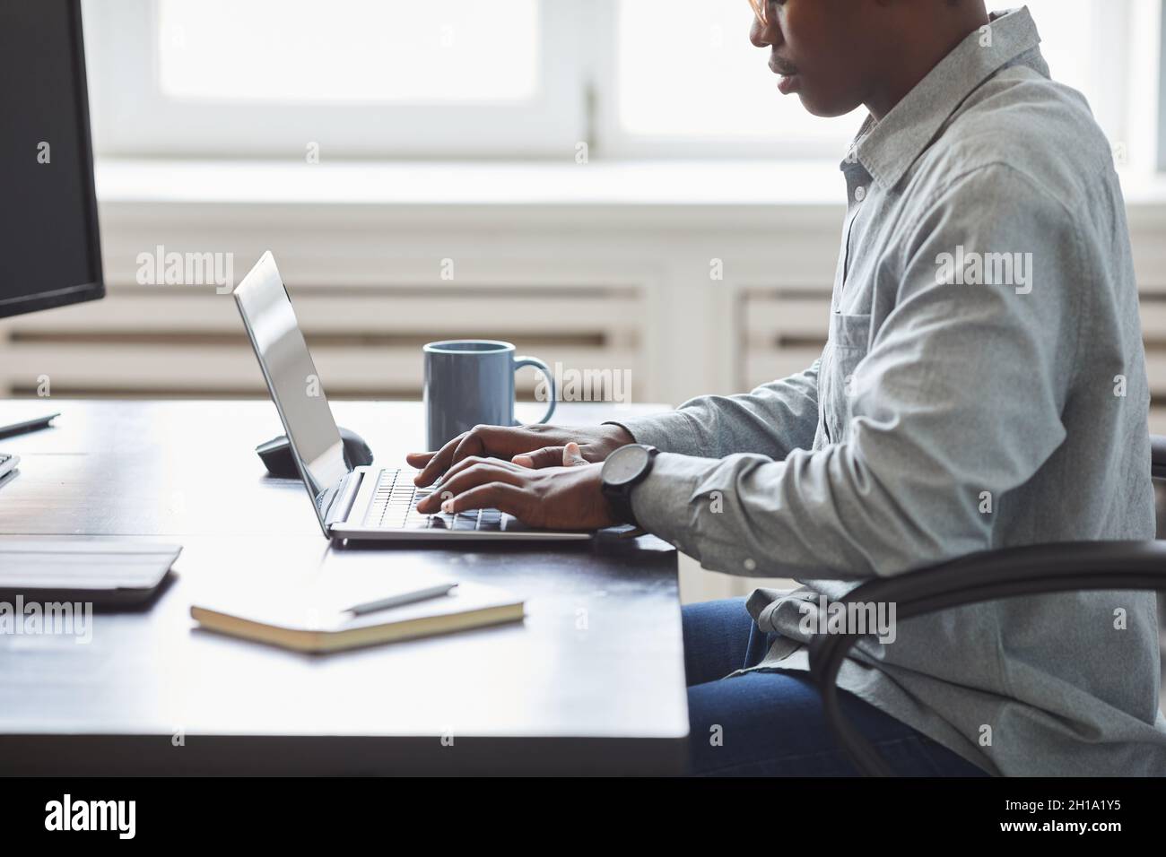 mixed race young woman typing on computer keyboard at table with