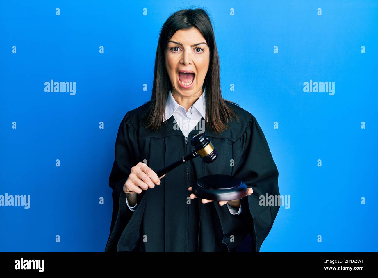 People Using Gavel Young hispanic woman using gavel celebrating crazy and amazed for ...