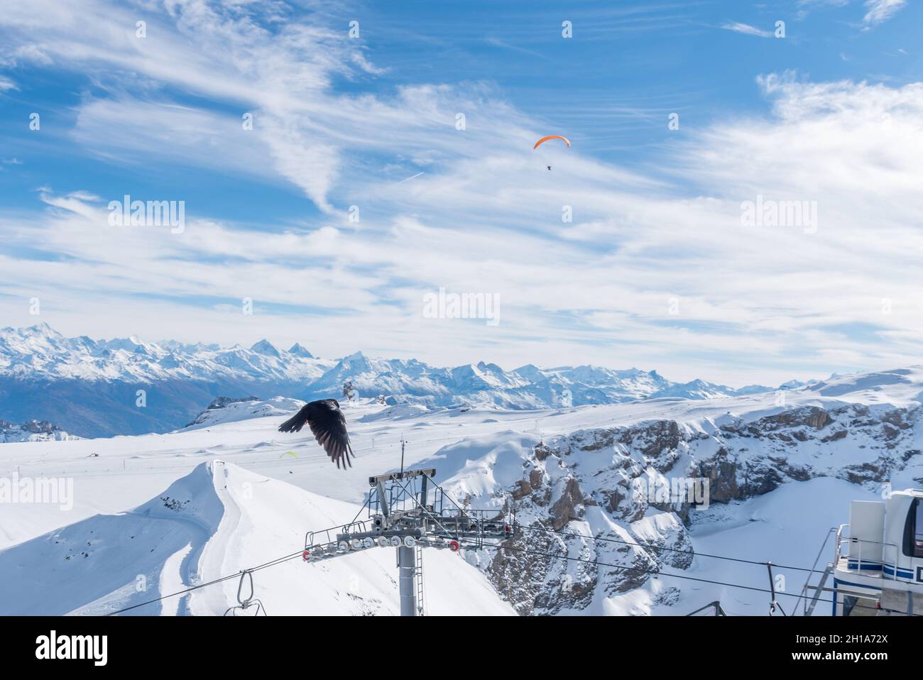 Landscape of the Diablerets Glacier at 3000 meters altitude a bird flying and a person doing paraglider Stock Photo