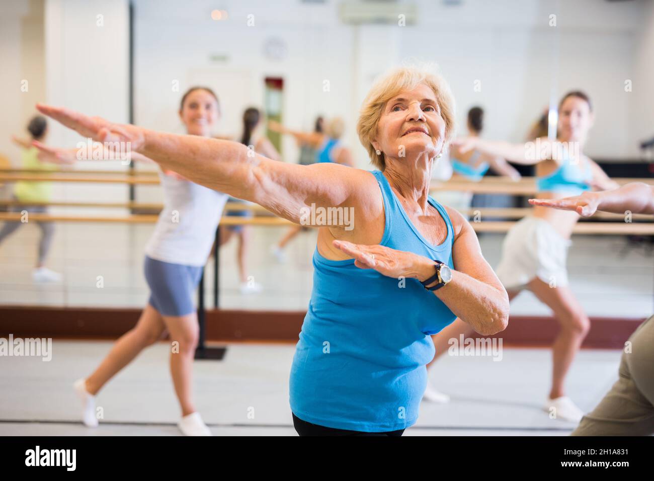 Old lady dancing with group in studio Stock Photo