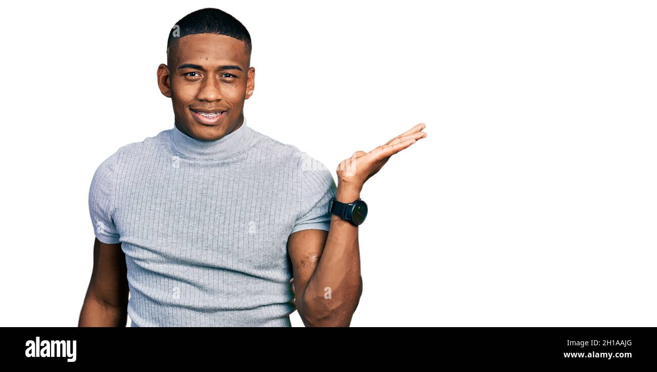 Young black man wearing casual t shirt smiling cheerful presenting and ...