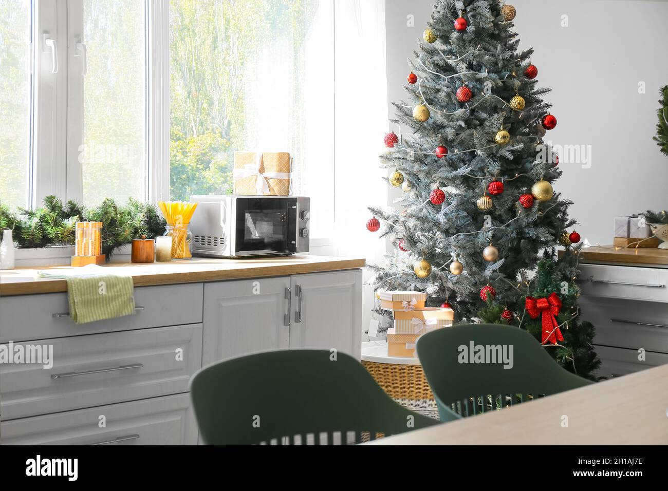 Interior of modern kitchen with beautiful Christmas tree Stock Photo