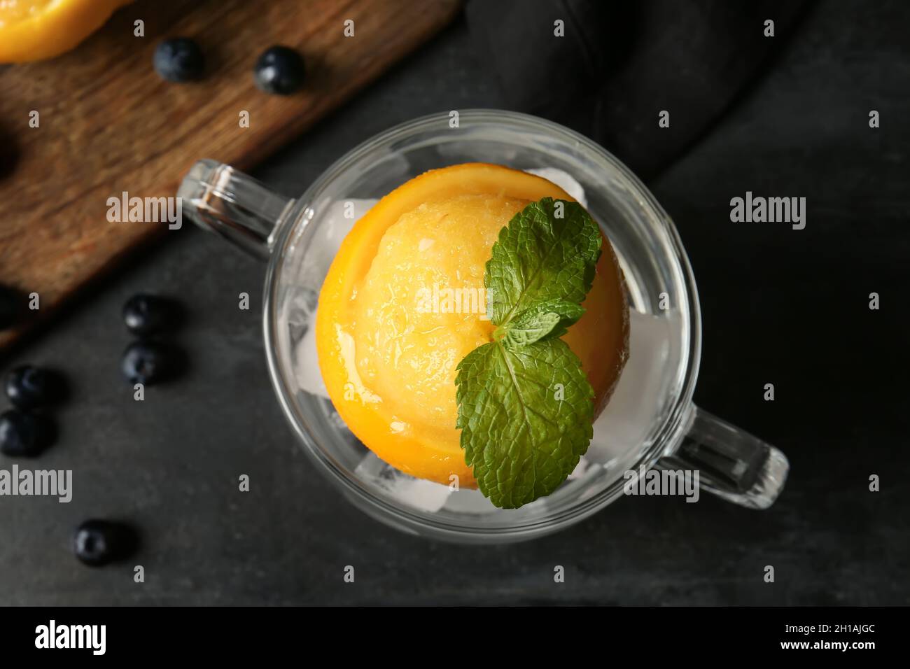 Bowl with tasty ice cream in orange peel on dark background Stock Photo