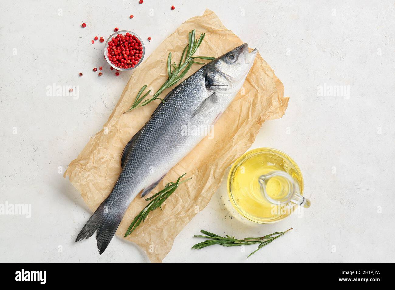 Fresh uncooked sea bass fish on white background Stock Photo - Alamy
