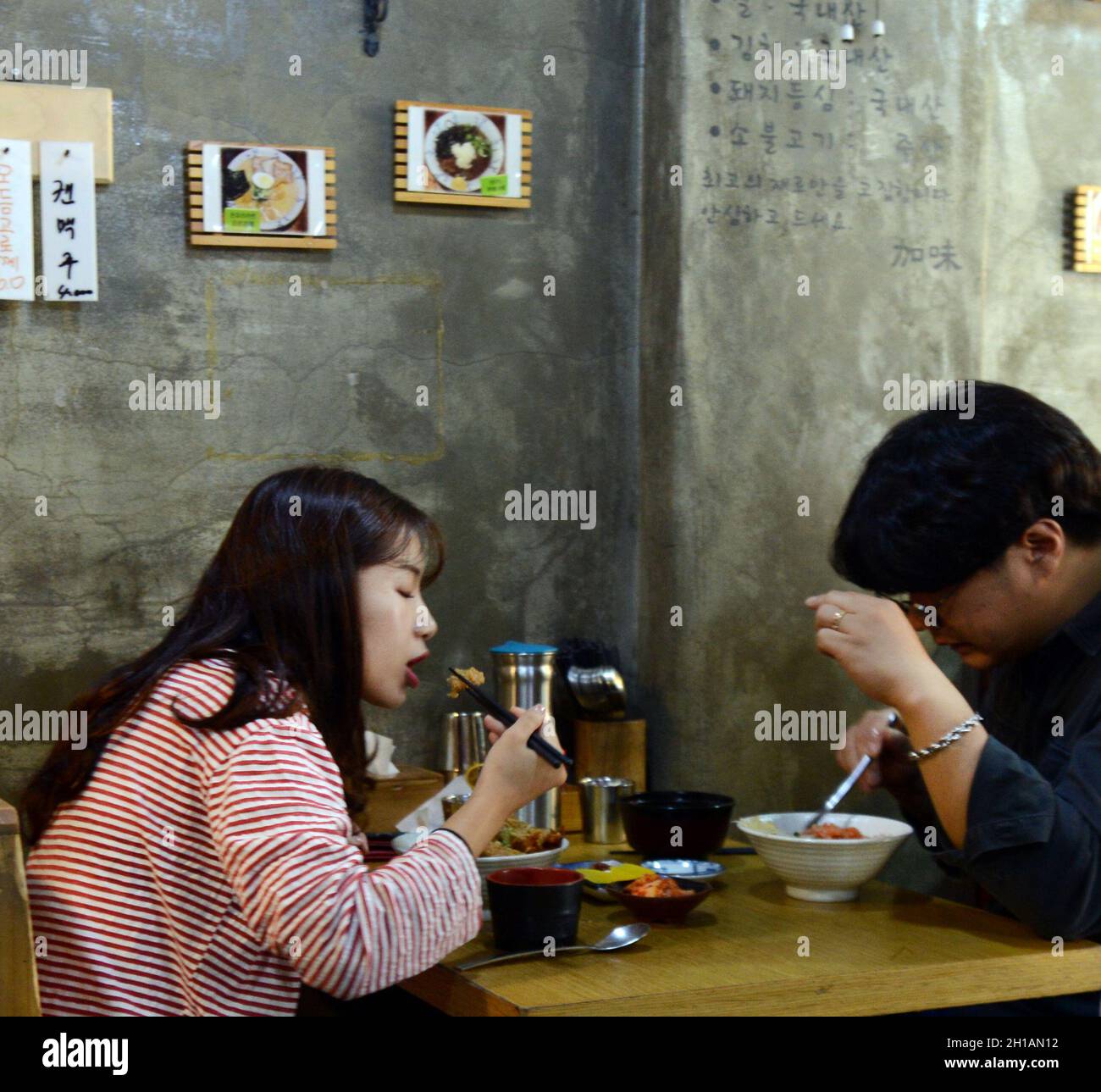 A Korean couple enjoying a Korean lunch in a restaurant in Seoul, Korea. Stock Photo